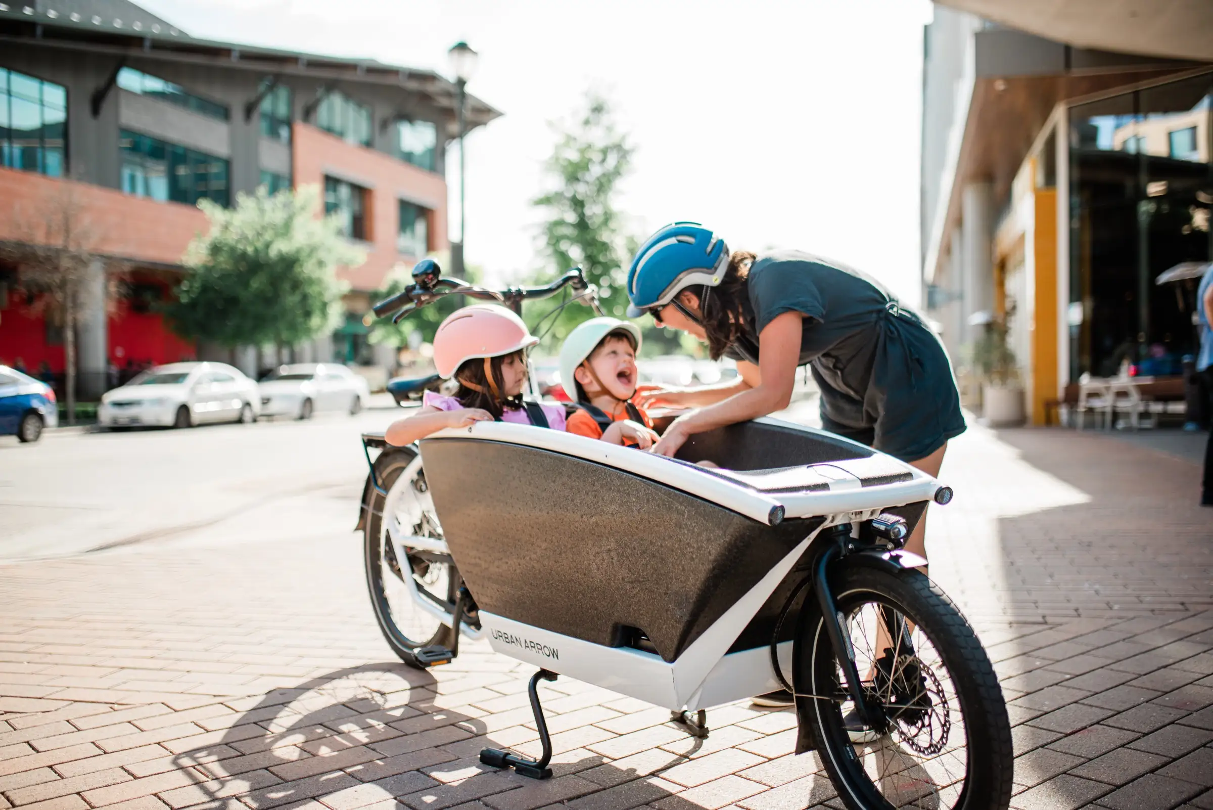 Mom with two kids riding in an Urban Arrow cargo bike